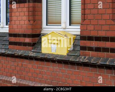 In eine Wand eingemauerter gelber Briefkasten alt DDR deutscher Postbriefkasten Rügen Sassnitz rostiger GDR Post-Briefkasten von früher damals Foto Stock