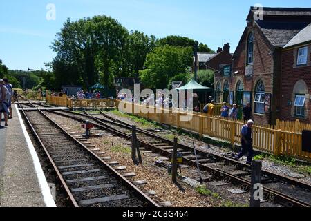 Persone in attesa di salire a bordo di un treno alla stazione dell'Isola di Wight. Foto Stock