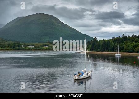 Con il Ponte Ballachulish e l'Hotel sullo sfondo, yacht ormeggiati in una tranquilla insenatura sulle rive del lago Leven. Foto Stock