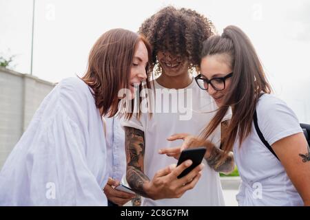 Gruppo misto di amici che si riuniscono in città. Foto Stock