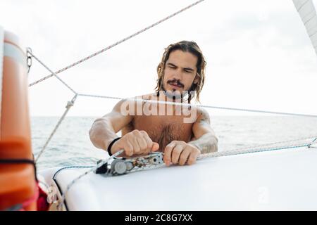 L'uomo la preparazione di barca a vela Foto Stock