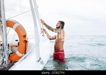 L'uomo la preparazione di barca a vela Foto Stock