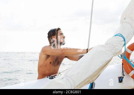 L'uomo la preparazione di barca a vela Foto Stock