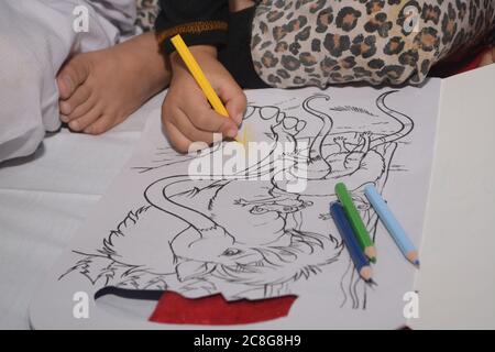 QUETTA, BALOCHISTAN, PAKISTAN. 24 luglio-2020: Un bambino paziente che cerca di colorare la forma in libro da colorare donato da oggi organizzazione femminile durante wa Foto Stock