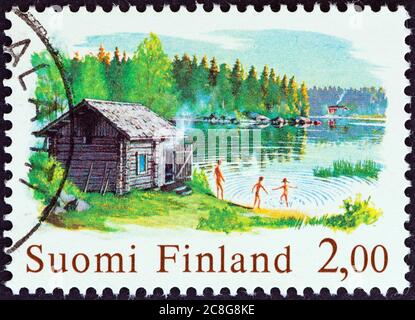 FINLANDIA - CIRCA 1977: Un francobollo stampato in Finlandia dal numero 'Arti finlandesi tradizionali' mostra sauna e lago, circa 1977. Foto Stock