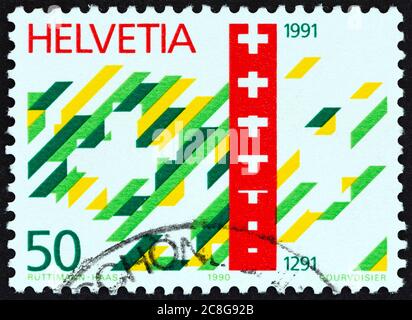 SVIZZERA - CIRCA 1990: Un francobollo stampato in Svizzera dal '700° anniversario della Confederazione svizzera' mostra emblema e croce dell'anniversario. Foto Stock