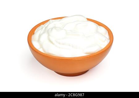 Panna acida, yogurt o formaggio fresco morbido in ciotola di ceramica isolata su sfondo bianco. Prodotti caseari naturali. Profondità di campo completa con tracciato di ritaglio Foto Stock