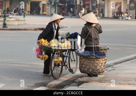 Hanoi Vietnam 20/12/2013 venditori di strada con bicicletta con fiori e frutta Foto Stock