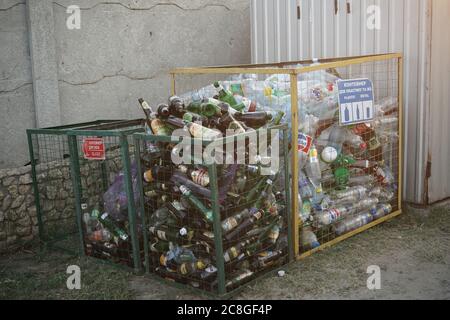 Bottiglie di vetro e plastica in contenitori per rifiuti. Smistamento e riciclaggio dei rifiuti. Agosto 2018, Odessa, Ucraina Foto Stock