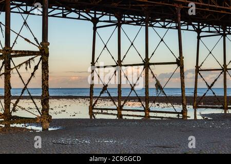 Bassa marea sulla spiaggia di Worthing, con vista sotto il molo, con luce notturna Foto Stock