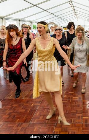 Donne vestite in costume d'epoca Danza alla Grande Fiera di Gatsby, Bexhill on Sea, East Sussex, UK Foto Stock