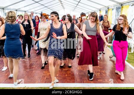 Donne che ballano alla grande fiera di Gatsby, Bexhill sul mare, Sussex orientale, Regno Unito Foto Stock