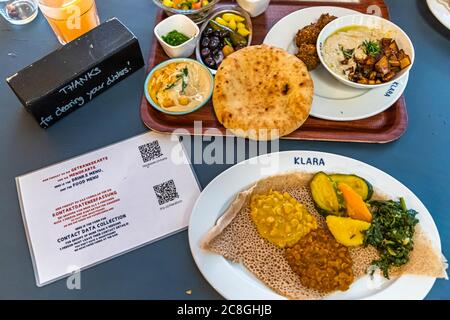 Klara Food Court durante le misure di Corona a Basilea, Svizzera. Cucina crossover: Piatti tipici dell'Eritrea e di Israele, comprese le norme igieniche ai tempi di Corona. Foto Stock