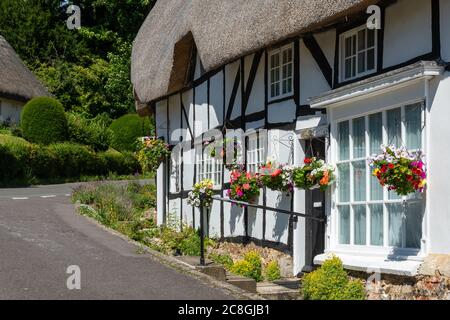 Graziosi cottage con tetto di paglia nel villaggio Hampshire di Wherwell, Inghilterra, Regno Unito, durante l'estate Foto Stock