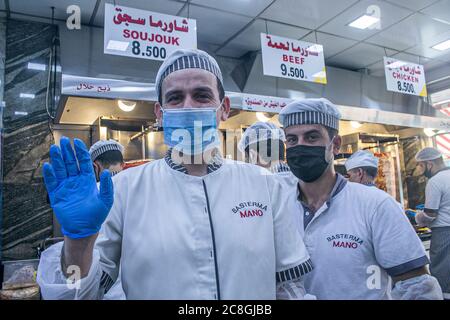 BEIRUT LIBANO. 24 luglio 2020. Lavoratori al mano sandwich nel distretto armeno di bourj Hammoud indossare maschere di protezione contro le infezioni covid-19 come servire i clienti. Il Libano ha confermato 156 nuovi casi di COVID-19 continuando una tendenza al rialzo delle infezioni giornaliere. Credit: amer Ghazzal/Alamy Live News Foto Stock