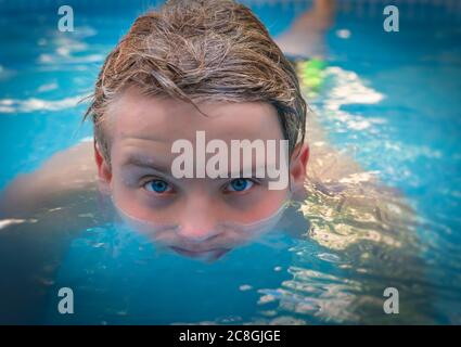 yong uomo con gli occhi blu stupefacente in piscina, godendo la sua vacanza. Foto Stock