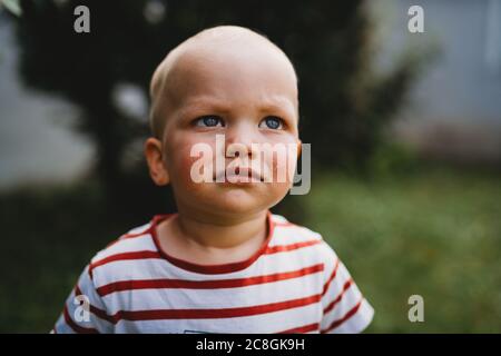 Vista frontale ritratto di ragazzo con serio e sporco faccia all'aperto Foto Stock