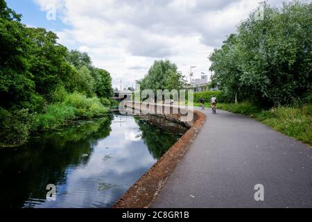 Ciclisti sull'alzaia del fiume Lea che attraversa il Queen Elizabeth Olympic Park a Stratford, Newham UK 2020 Foto Stock