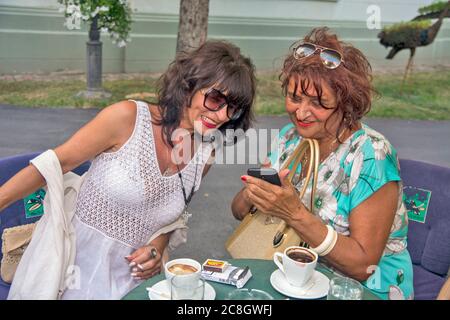 Zrenjanin, Serbia, 06 settembre 2019. Due amici sono seduti in un bar e parlano casualmente di foto sul loro telefono. Foto Stock