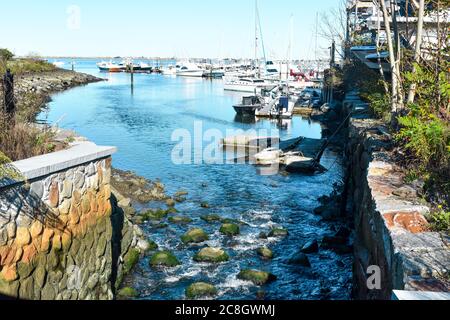 Town Brook che scorre su rocce nel porto di Pymouth vicino alle barche presso la Marina di Plymouth Foto Stock