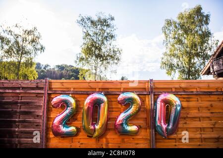 Eggingen, Germania. 24 luglio 2020. Quattro palloncini, che insieme formano la scritta '2020', appendono da una recinzione presso la stazione ferroviaria di Eggingen. Le tre classi di laurea della scuola secondaria di Stühlingen ricevono i loro certificati durante il viaggio in treno da Eggingen a Stühlingen - poiché non può avvenire alcuna normale cerimonia di laurea a causa della pandemia di Corona. Credit: Philippe von Ditfurth/dpa/Alamy Live News Foto Stock