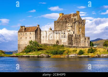 Dornie, SCOZIA: Giorni estivi con un cielo blu sopra il bellissimo castello scozzese di Eilean Donan nel mezzo di un lago. Foto Stock