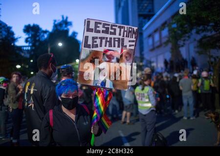 Portland, OREGON, Stati Uniti. 23 luglio 2020. Meghan Opbroek, 36 anni, di Portland, ha un cartello con le fotografie che mostra le ferite subite dal Portland Police Bureau durante le manifestazioni iniziate la sera del 25 giugno. Opbroek è stato colpito da una granata stun, comunemente noto come un flash bang. Ora ha bisogno di un cane a piedi, ha ustioni di terzo grado, medici ha dovuto rimuovere la pelle da più aree e ha post-confusion syndrome.migliaia di persone continuano a protestare la città occupazione da parte di ufficiali federali.Photoge: Katharine Kimball.Title: Contratto Photographer.Credit: Zuma Press.City: Por Foto Stock