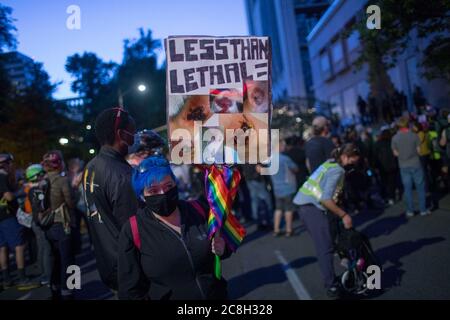 Portland, OREGON, Stati Uniti. 23 luglio 2020. Meghan Opbroek, 36 anni, di Portland, ha un cartello con le fotografie che mostra le ferite subite dal Portland Police Bureau durante le manifestazioni iniziate la sera del 25 giugno. Opbroek è stato colpito da una granata stun, comunemente noto come un flash bang. Ora ha bisogno di un cane a piedi, ha ustioni di terzo grado, medici ha dovuto rimuovere la pelle da più aree e ha post-confusion syndrome.migliaia di persone continuano a protestare la città occupazione da parte di ufficiali federali.Photoge: Katharine Kimball.Title: Contratto Photographer.Credit: Zuma Press.City: Por Foto Stock