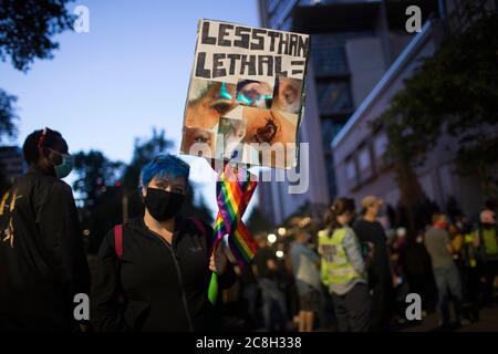 Portland, OREGON, Stati Uniti. 23 luglio 2020. Meghan Opbroek, 36 anni, di Portland, ha un cartello con le fotografie che mostra le ferite subite dal Portland Police Bureau durante le manifestazioni iniziate la sera del 25 giugno. Opbroek è stato colpito da una granata stun, comunemente noto come un flash bang. Ora ha bisogno di un cane a piedi, ha ustioni di terzo grado, medici ha dovuto rimuovere la pelle da più aree e ha post-confusion syndrome.migliaia di persone continuano a protestare la città occupazione da parte di ufficiali federali.Photoge: Katharine Kimball.Title: Contratto Photographer.Credit: Zuma Press.City: Por Foto Stock