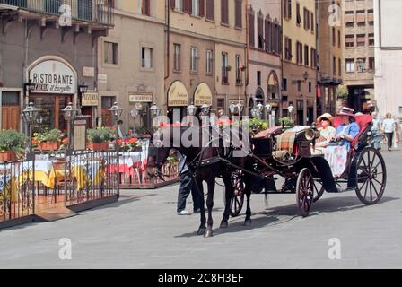 Italiano di cavallo e aprire il trasporto di due donne che i passeggeri in arrivo al marciapiede ristoranti & bar in Piazza della Signoria a Firenze Toscana Italia EU Foto Stock