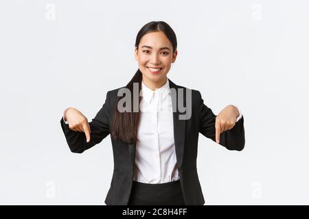 Professionista sicuro venditore suggeriscono buon affare, prezzi migliori. Sorridente buon-osservante agente immobiliare femminile che mostra il basso advertisemenet Foto Stock