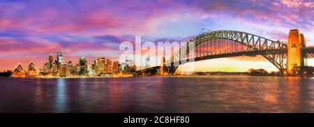 Tramonto luminoso e colorato sui punti di riferimento del CBD di Sydney con il Ponte del Porto. Foto Stock