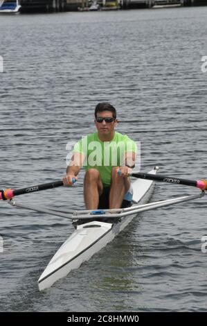 Vogatore e il suo singolo cranio che si dirige verso l'esterno per una fila sulla baia. Foto Stock