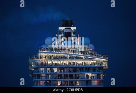 Amburgo, Germania. 24 luglio 2020. I passeggeri a bordo della nave da crociera Tui 'Mein Schiff 2' seguiranno la partenza dal porto in serata per un viaggio di andata e ritorno di tre giorni sul Mare del Nord in direzione della Norvegia. Per la prima volta in assoluto, una grande nave da crociera ha lasciato un porto tedesco dopo mesi di pausa forzata. (Per dpa 'la prima grande nave da crociera ha navigato per un breve viaggio') credito: Daniel Bockwoldt/dpa/Alamy Live News Foto Stock