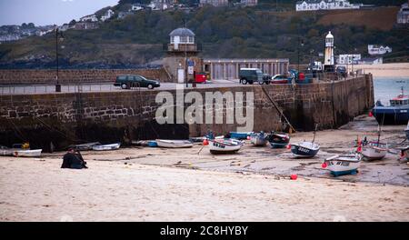 St Ives, UK 03/09/2010: Un panorama al tramonto di una spiaggia all'interno del porto di pescatori di St Ives. L'immagine presenta piccole barche intrecciate sulla sabbia in bassa marea, una coppia Foto Stock