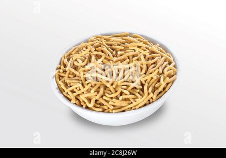 Ratlami Sev, fritto e piccante, è uno spuntino gujarati molto popolare, ciotola bianca su sfondo bianco, bustina che impacchettano lo spuntino di strada comune dall'India. - immagine Foto Stock