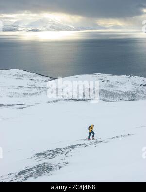 Sciatori in salita nelle alpi norvegesi settentrionali di Lyngen Foto Stock