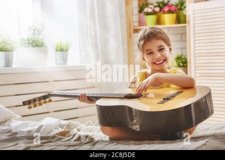 Grazioso fanciullo ragazza a suonare la chitarra. Foto Stock