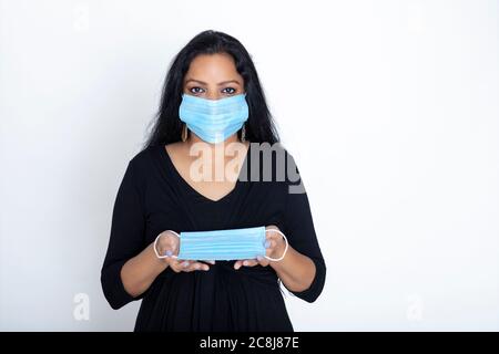 Donna indiana che indossa maschera di protezione Covid, le donne mostrano l'uso di maschera facciale Foto Stock
