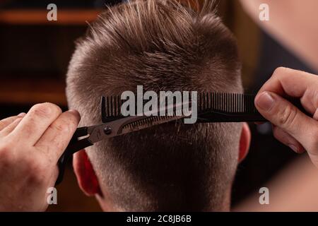 taglio dei capelli da uomo. taglio dei capelli con forbici da primo piano. utensili per capelli Foto Stock