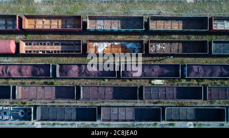 Vista aerea della stazione ferroviaria di smistamento merci con le automobili ferroviarie, con molte rotaie ferroviarie. Panorama industriale pesante. Foto Stock