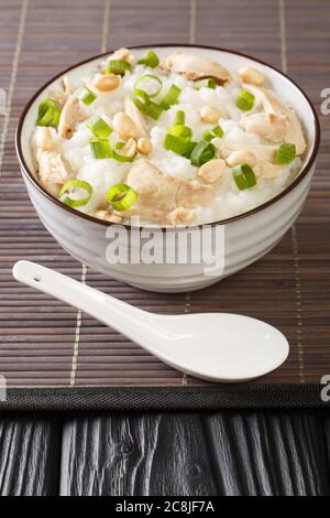 Pollo allo zenzero porridge di riso di Jook da vicino in una ciotola sul tavolo. Verticale Foto Stock