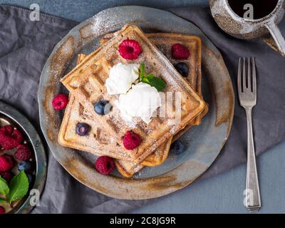 Waffle belgi con lamponi, sciroppo di cioccolato. Colazione con tè Foto Stock