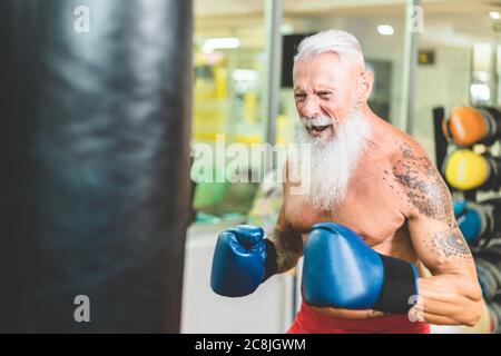 Hipster uomo senior boxing dentro allenamento fitness palestra club - pugile maturo fare sessione di allenamento - Sport, autodifesa e stile di vita sano concep Foto Stock