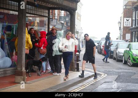 Rye, Sussex orientale, Regno Unito. 25 Jul 2020. UK Weather: I visitatori dell'antica città di Rye in East Sussex camminano per la strada alta con alcune persone che indossano maschere nonostante la pioggia. Molte persone si attengono ai consigli del nuovo governo sull'uso di maschere nei negozi. Persone che riparano dalla pioggia. Photo Credit: Paul Lawrenson-PAL Media/Alamy Live News Foto Stock