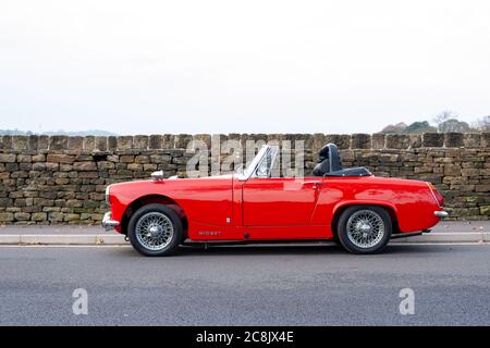 MG Midget parcheggiato da un muro di pietra su una strada di campagna Foto Stock