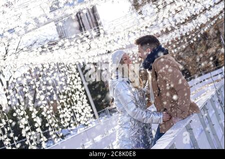 Giovane coppia che si guarda romanticamente nel parco in inverno Foto Stock