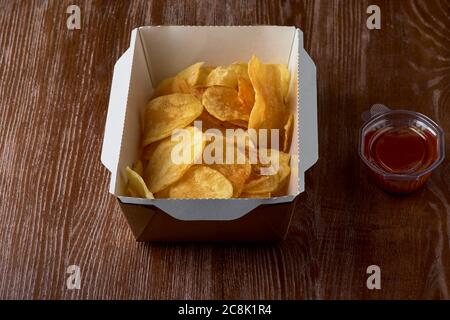 Deliziosi patatine dolci con ketchup su una scatola di cartone da portare via. Foto Stock