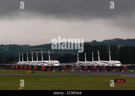 Glasgow, Scozia, Regno Unito. 23 luglio 2020. Nella foto: Sotto una nuvola di tempesta oscura minacciosa, gli aerei della British Airways (BA) a terra A319/A320/A321 si trovano nella seconda pista dell'aeroporto di Glasgow in attesa del loro destino di essere venduti o messi in deposito. Da marzo questi aerei sono stati inattivi sul asfalto aeroporti, doe alla crisi globale coronavirus (COVID19). British Airways ha tagliato quasi 12,000 dipendenti, e finora hanno ritirato tutta la flotta Boeing 747 per ridurre i costi operativi. Credit: Colin Fisher/Alamy Live News. Foto Stock