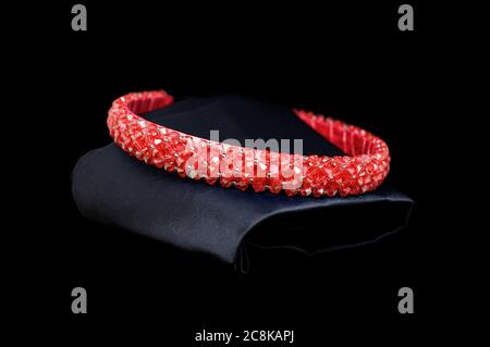 Rosso rubino tiara gemstones diamanti capelli banda su sfondo nero. Concetto isolato di esposizione di gioielli Foto Stock